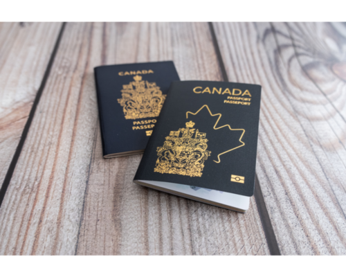Two Canadian passports resting on a wooden surface