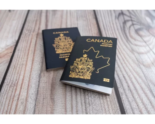Two Canadian passports resting on a wooden surface